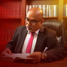 Gamini Perera seated at his desk